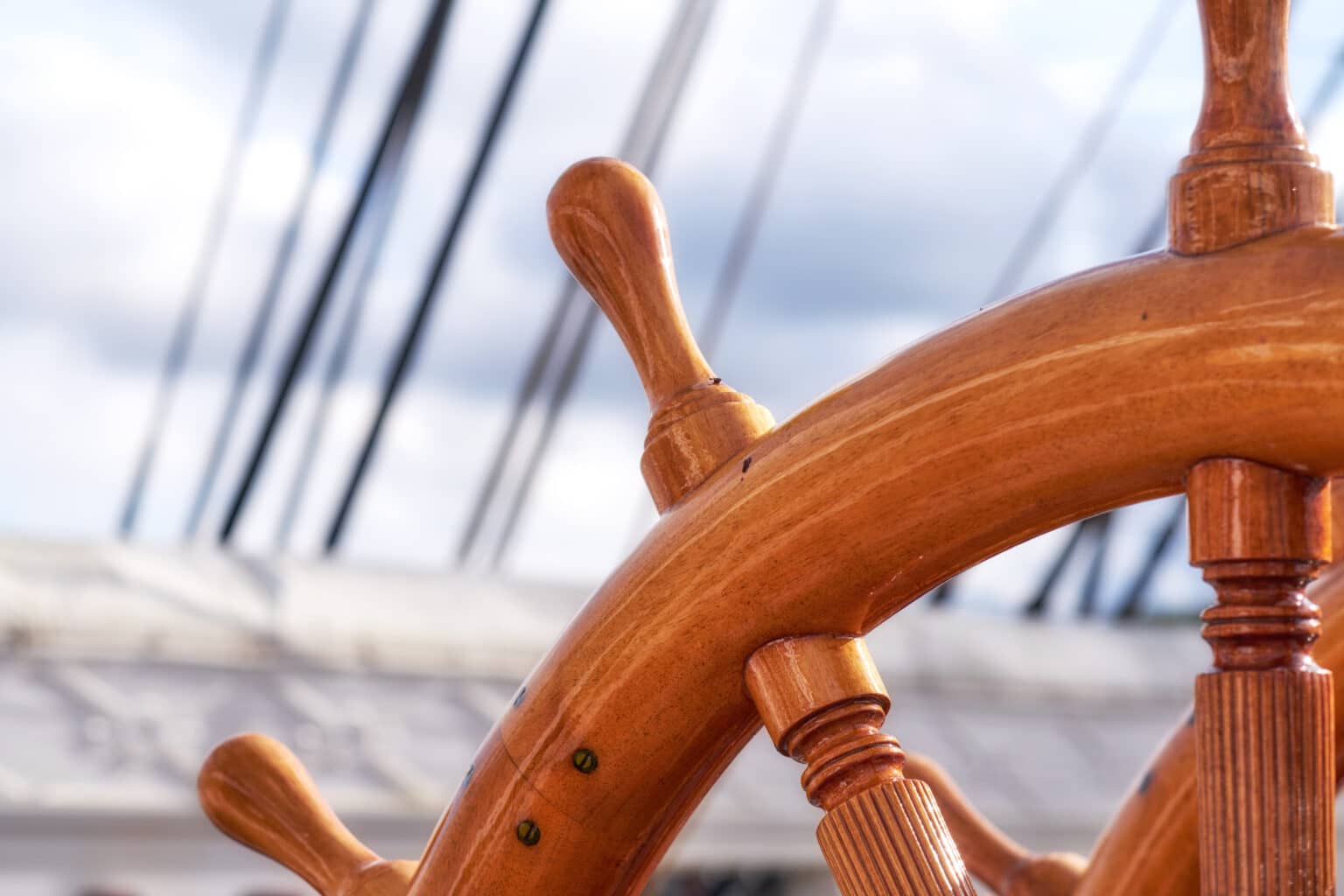 Close-up of a traditional wooden ship's wheel, representing the freedom to steer your own custom Komodo itinerary.